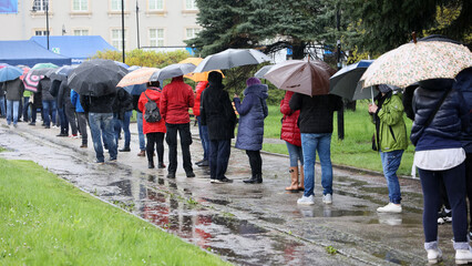  Ludzie pod parasolami czekają w kolejce do mobilnego punktu szczepień we Wrocławiu - obrazy, fototapety, plakaty