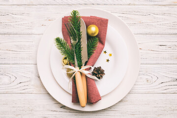 Christmas table place setting with christmas decor and plates, kine, fork and spoon. Christmas holiday background. Top view with copy space