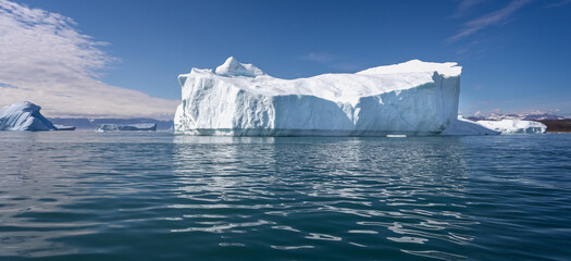 Massive icebergs with mountain backdrop in Disko Bay in Greenland