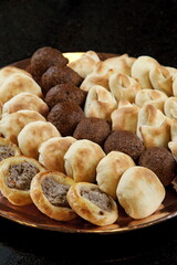 tray with open and closed sfihas and kibes. Classic snacks from Arabic cuisine.