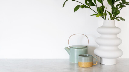 Blue kettle, cup and fresh flowers on kitchen table