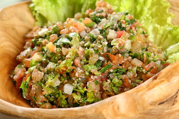 Tabbouleh, classic cold Arabic dish with tomatoes, wheat, green onions, parsley and onions