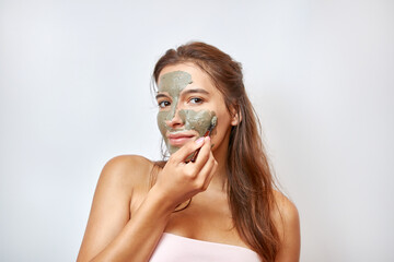 The girl uses blue clay for face care. Beauty concept, skin care cosmetics, facelift. Beauty salon. Wrinkle removal.