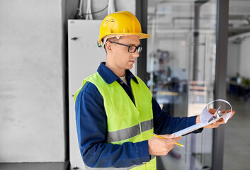 construction business and building concept - male electrician or worker in helmet and safety west...