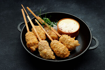 Tempura shrimp on a wooden stick in a pan