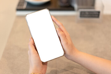 Business woman is showing white blank screen on smartphone while checking data and working about new project