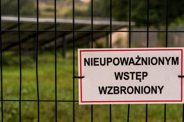Tabliczka z napisem NIEUPOWAŻNIONYM WSTĘP WZBRONIONY , wisząca na panelowym ogrodzeniu z siatki metalowej . © Grzegorz