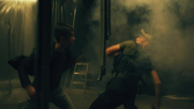 Movie scene montage for tv screens. Two characters fight in a dark room and a terrorist, a suicide bomber with a pistol who mined a man with explosives. Action movie scene fight playback scene 3.