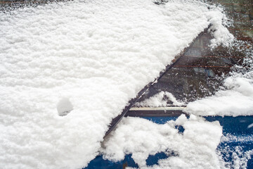 The rear window of the car is covered with snow