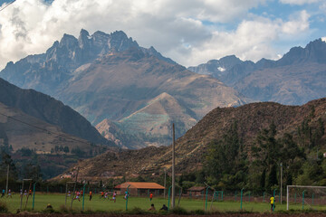 Football pitch with players in the mountains in the village of Urquillos. Sacred Valley, Peru. 