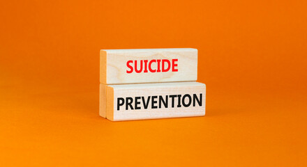 Suicide prevention symbol. Concept words Suicide prevention on wooden blocks. Beautiful orange table orange background. Psychological and suicide prevention concept. Copy space.