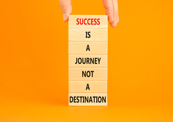 Success is a journey symbol. Concept words Success is a journey not a destination on wooden blocks on a beautiful orange background. Businessman hand. Business and success journey concept. Copy space