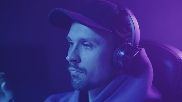 a gamer in a cap puts on headphones