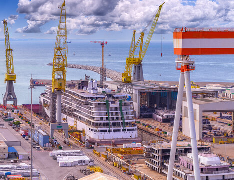 Close up on the shipyard, new luxury cruise ship under construction, cranes work to assemble the cruise ship