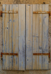 Building's facade. Wall of an old house. Closed wooden window. Architectural detail. Close-up