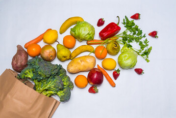 healthy food, fruits and vegetables in a shopping bag. vegetarian. white background