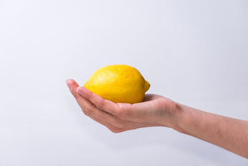 delicate hand holding a lemon, yellow, healthy living, lifestyle