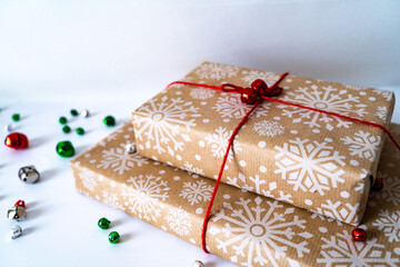 Brown Christmas gift box present with ribbon and bells against white background