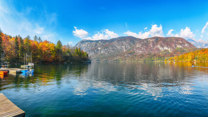 Fabulous view  of  Bohinj Lake with boats during autumn .