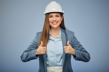Smiling woman builder in white safety industrial helmet. Isolated female portrait with thumbs up.