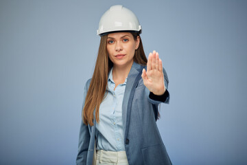 Concept on health and safety at construction site. Woman builder in safety industrial helmet. Isolated female portrait.