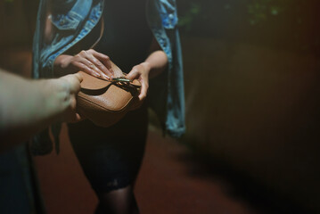 Thief snatches bag from woman on the night street.