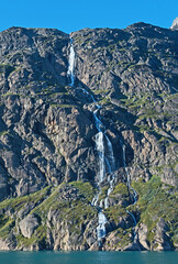 Obraz premium With mountains, glaciers and this beautiful waterfall, Prince Christian Sound in southern Greenland. Greenland offers tranquil waters and spectacular views.
