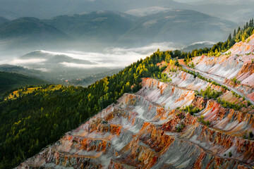 Gold and copper open pit mine in misty mountains - obrazy, fototapety, plakaty