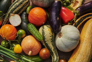 Various ripe autumn vegetables are laid out on the table. View from above.