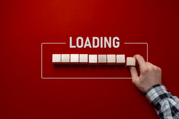 hand put a wooden cube in a row, loading progress bar