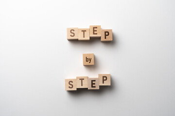 wooden cubes blocks with "step by step" text, personal growth concept