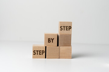 wooden cubes blocks with "step by step" text, personal growth concept