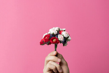 a person holding a mini flowers bouquet, happy holidays creative concept