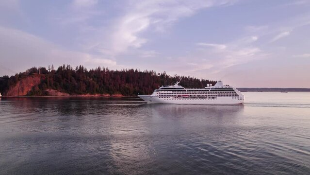 Cruise ship sailing out of Vancouver harbour at sunset, cruise line, large boat, luxury cruise, aerial footage. 4K 4096x2304 24FPS.