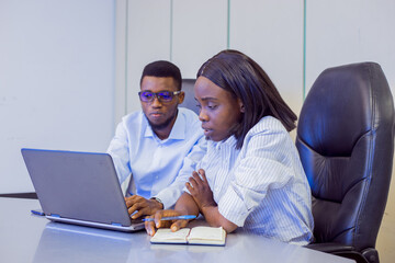 African businessman and woman in a conference room with a laptop