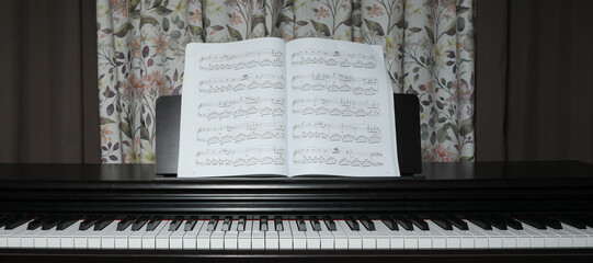black piano and sheet music, at home