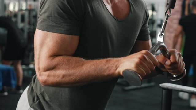 Muscular white man in t-shirt training with lat pull down machine. Close up on chest and biceps. Power lifting. Fitness. Horizontal. High quality 4k footage