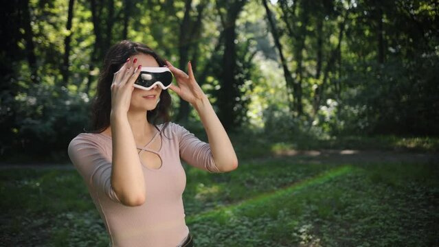 A world of boundless imagination, blending with nature perfectly in the future, a beautiful woman stands in the outdoor park touching a screen with virtual reality.