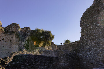 High angle view of ancient roman ruins in Sirmione, Italy. Incidental people in silhouette on the background. Copy space.
