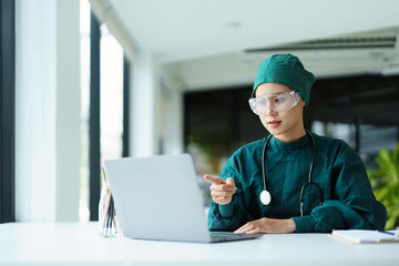Asian doctor using a computer to look at patient information.