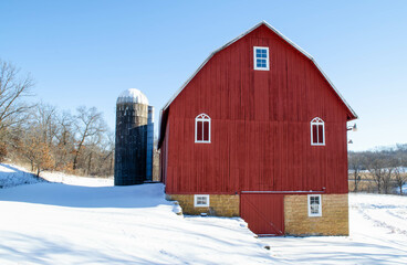 A red barn on a snowy property with winter trees  © MLWilson