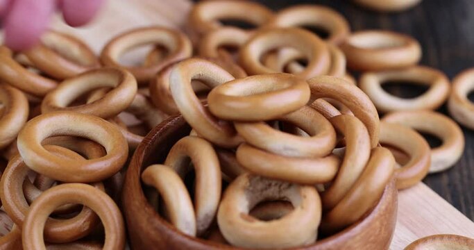 folding and putting hard bagels in a plate, delicious traditional Russian food round bagels for tea