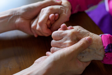 A young man and an old man holding hands - obrazy, fototapety, plakaty