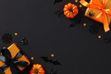 Happy Halloween holiday composition. Flat lay orange gift boxes with ribbon bow, pumpkins, bats,...