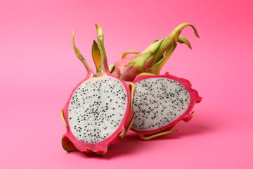 Delicious cut and whole dragon fruits (pitahaya) on pink background