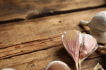 Fresh organic garlic on wooden table, closeup. Space for text