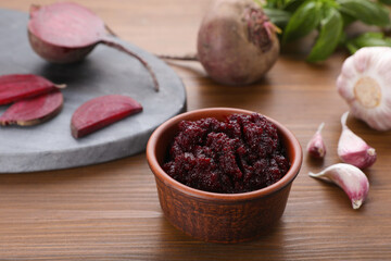 Obraz na płótnie Canvas Bowl with tasty beet puree and ingredients on wooden table