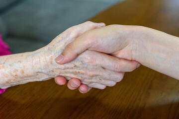 A young man and an old man holding hands