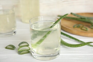 Fresh aloe drink on light wooden table, closeup