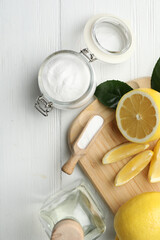Baking soda, vinegar and cut lemons on white wooden table, flat lay